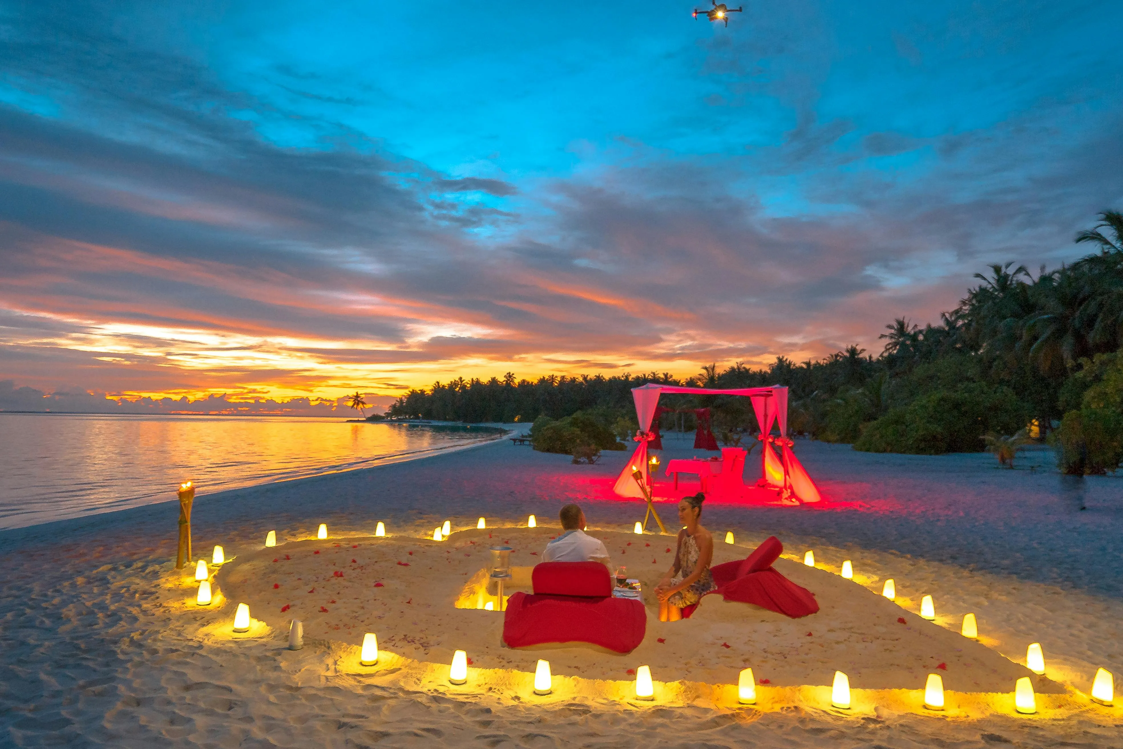 Private sunset dinner setup on the beach